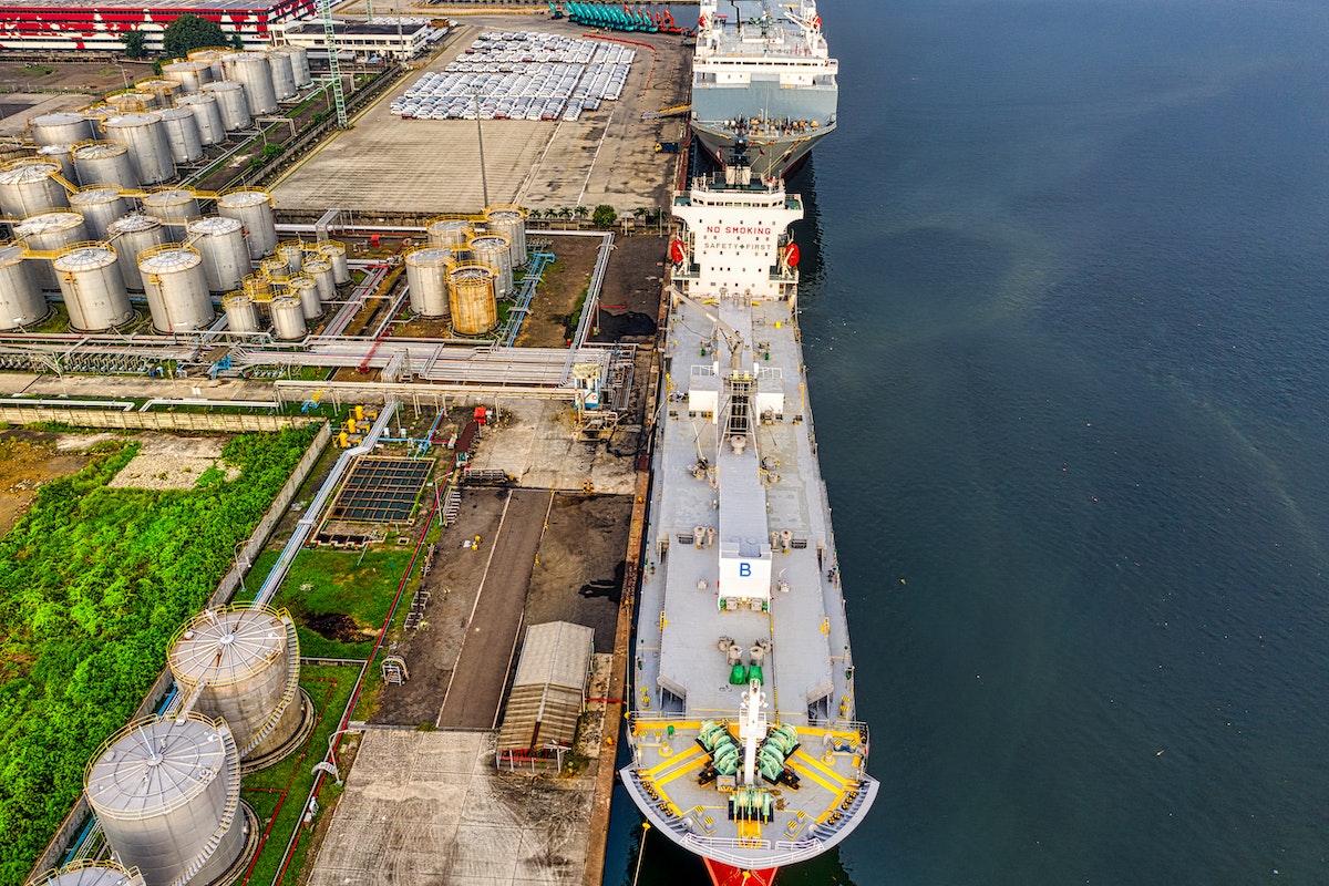 Imagem de um porto onde tem dois grandes cargueiros atracados